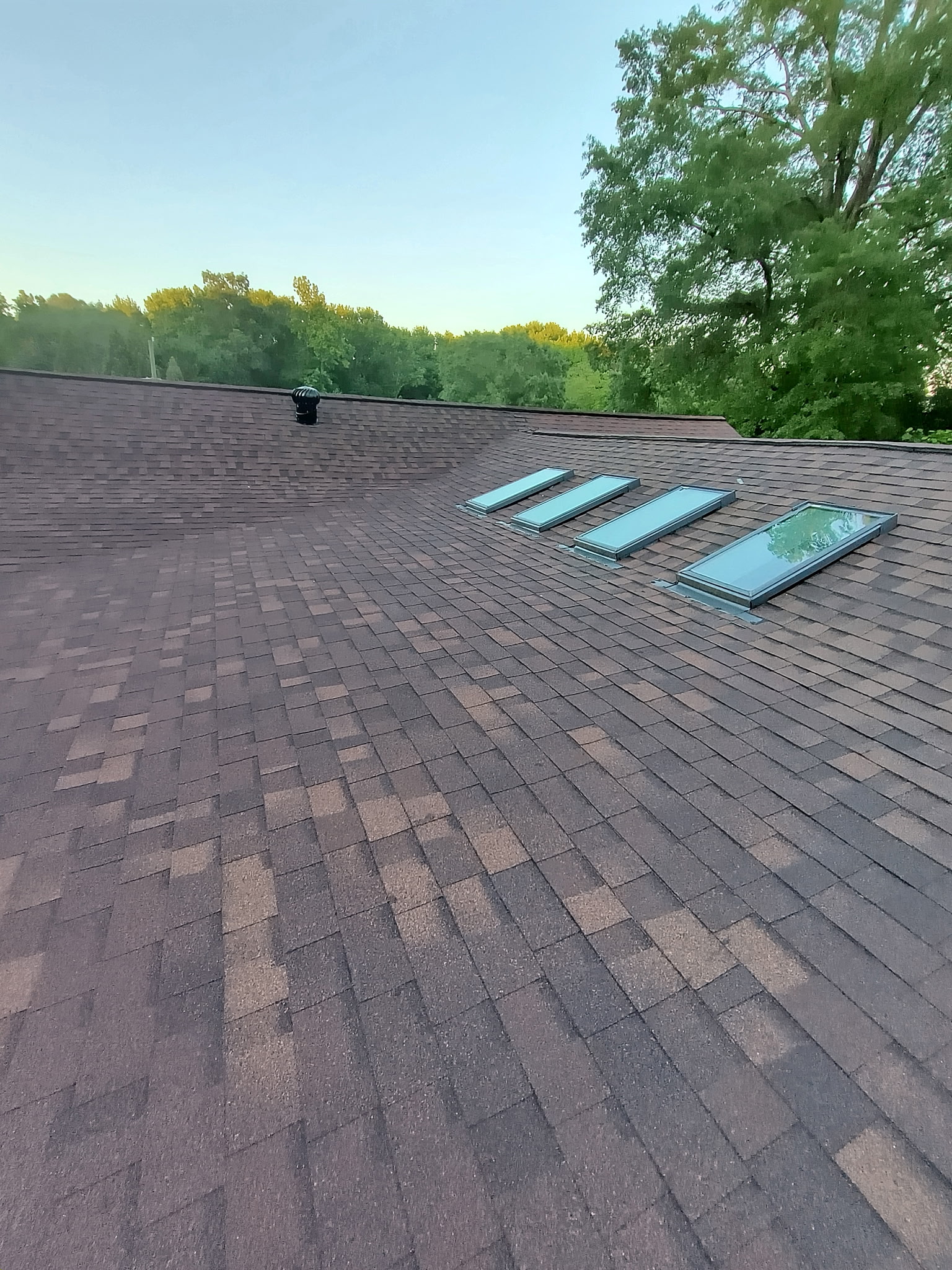 Completed brown architectural shingle roof with skylights — Charlotte NC